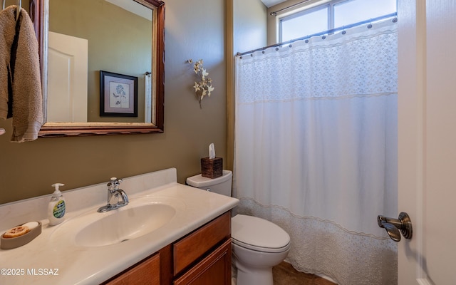 bathroom with curtained shower, toilet, and vanity