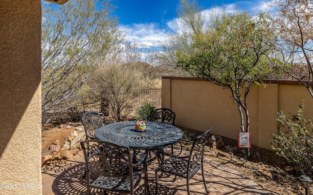 view of patio featuring outdoor dining space and fence