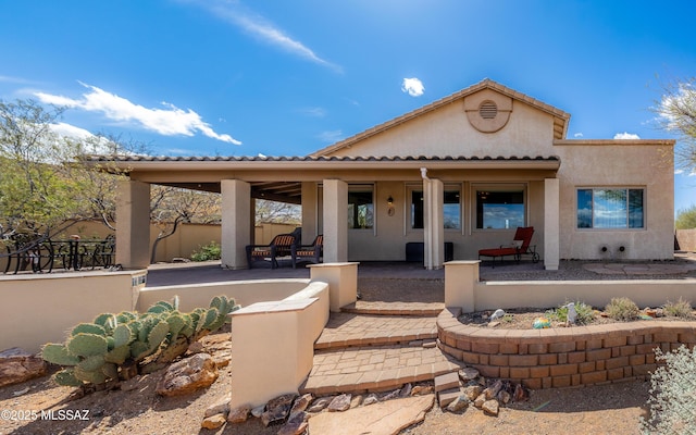 rear view of property featuring stucco siding and a porch