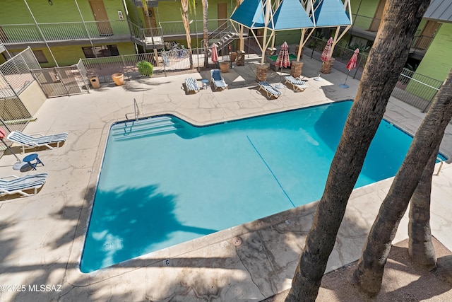 community pool featuring a patio and fence