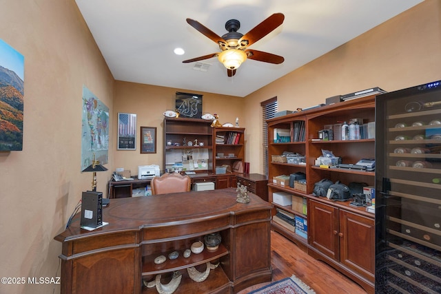 office space featuring visible vents, light wood-style floors, and a ceiling fan