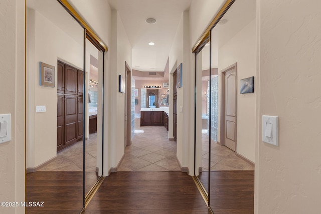 hall with recessed lighting, baseboards, and light wood-style floors