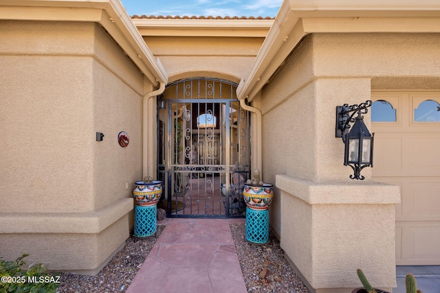 property entrance with a gate and stucco siding