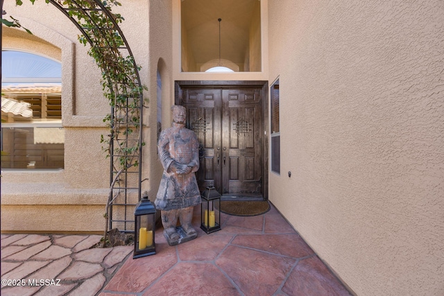 view of exterior entry featuring stucco siding