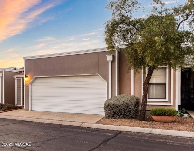 view of front of property featuring an attached garage and stucco siding