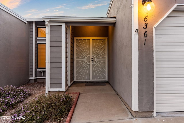 entrance to property featuring stucco siding