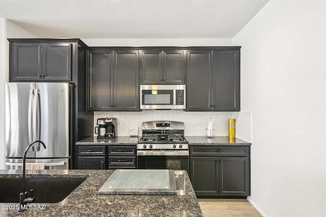 kitchen featuring tasteful backsplash, stainless steel appliances, and dark stone counters