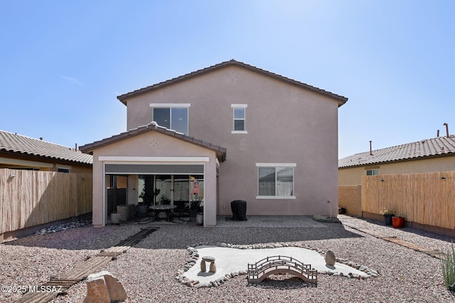 back of property featuring a tile roof, a patio area, a fenced backyard, and stucco siding