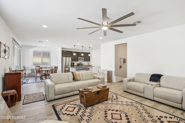 living room with visible vents, recessed lighting, light wood-type flooring, and ceiling fan