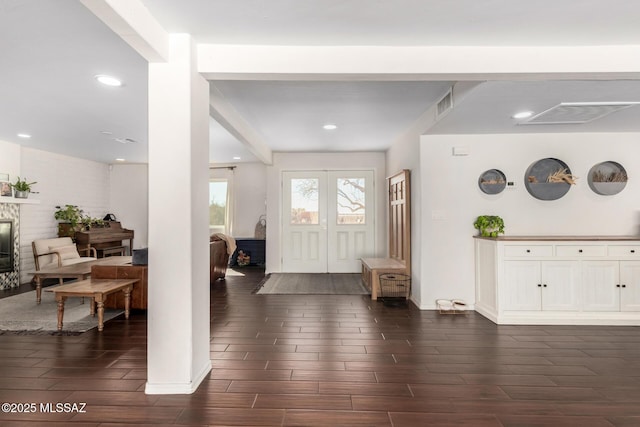 entrance foyer featuring visible vents, a glass covered fireplace, french doors, wood finish floors, and recessed lighting