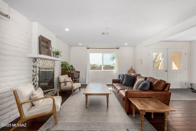 living room with french doors, a fireplace, recessed lighting, visible vents, and wood finished floors