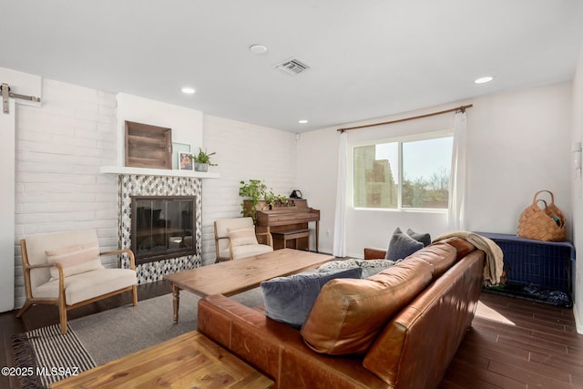 living area with recessed lighting, visible vents, a barn door, a glass covered fireplace, and wood finished floors