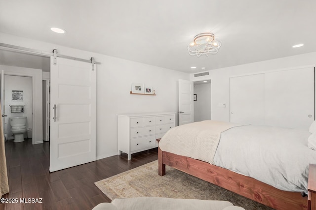 bedroom with dark wood-style floors, recessed lighting, a closet, visible vents, and a barn door