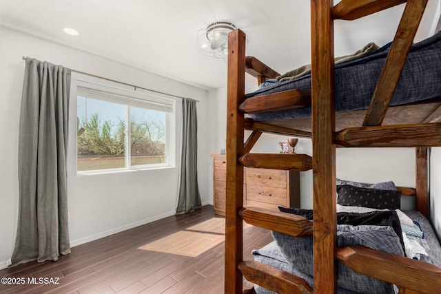 bedroom with wood finish floors and baseboards