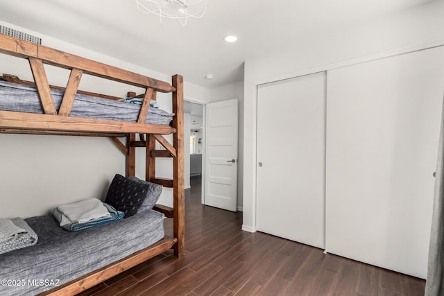 bedroom with dark wood-style flooring, a closet, and recessed lighting