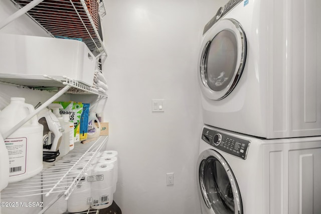 laundry area featuring stacked washer / drying machine and laundry area