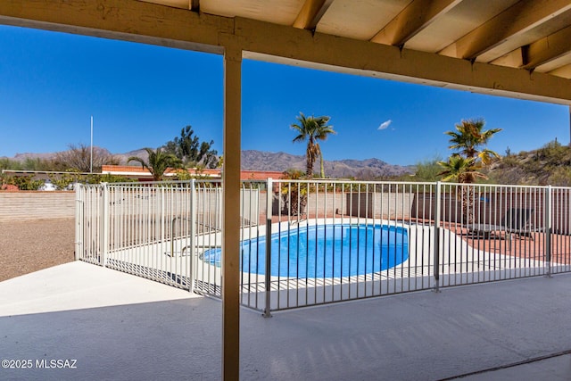 view of swimming pool featuring a fenced in pool, a patio, fence, and a mountain view