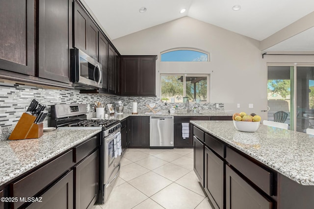 kitchen with appliances with stainless steel finishes, a wealth of natural light, and tasteful backsplash
