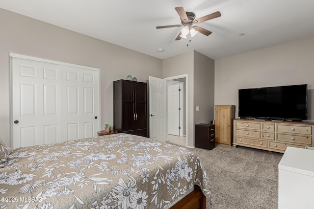 carpeted bedroom with ceiling fan and a closet