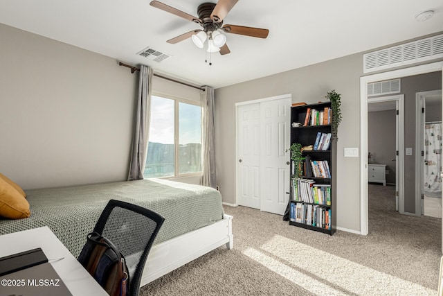 bedroom featuring a ceiling fan, a closet, visible vents, and carpet flooring