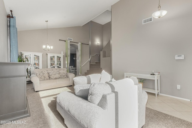 carpeted living room with visible vents, tile patterned floors, stairs, high vaulted ceiling, and a notable chandelier