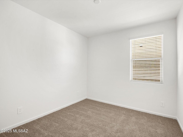 carpeted spare room with baseboards