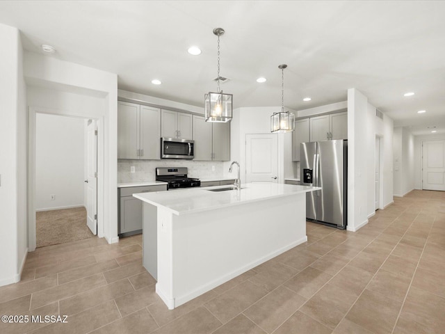 kitchen with appliances with stainless steel finishes, gray cabinetry, a sink, recessed lighting, and decorative backsplash
