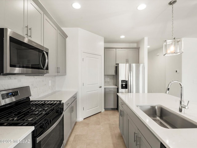 kitchen with stainless steel appliances, gray cabinets, a sink, decorative backsplash, and recessed lighting