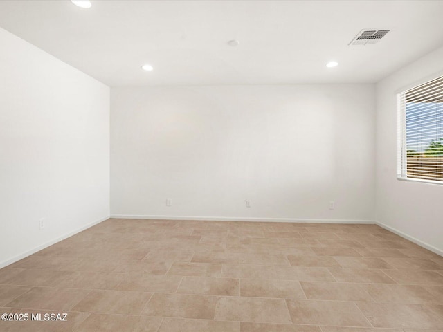 empty room featuring recessed lighting and baseboards