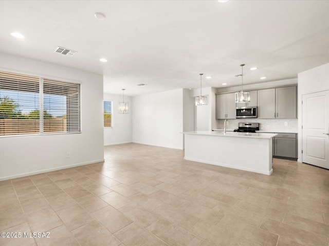 kitchen featuring appliances with stainless steel finishes, recessed lighting, gray cabinetry, light countertops, and open floor plan