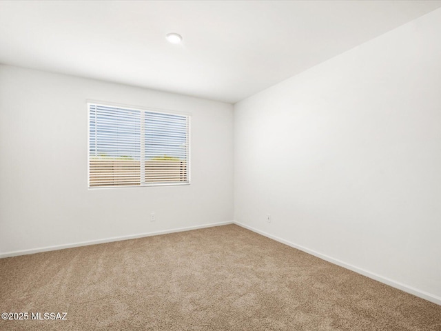 carpeted spare room with baseboards
