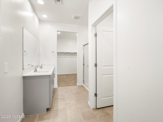 full bathroom featuring vanity, recessed lighting, a spacious closet, baseboards, and tile patterned floors