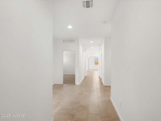 corridor featuring recessed lighting, light tile patterned flooring, and baseboards