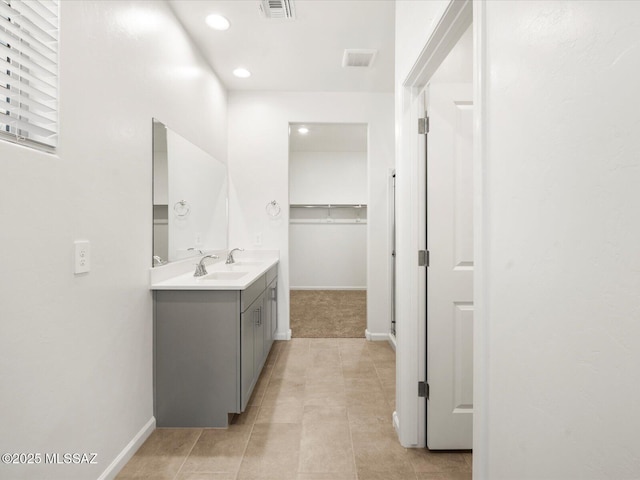bathroom featuring vanity, baseboards, recessed lighting, tile patterned floors, and a spacious closet