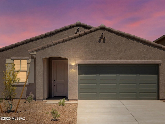 view of front of home with driveway, stucco siding, and a garage