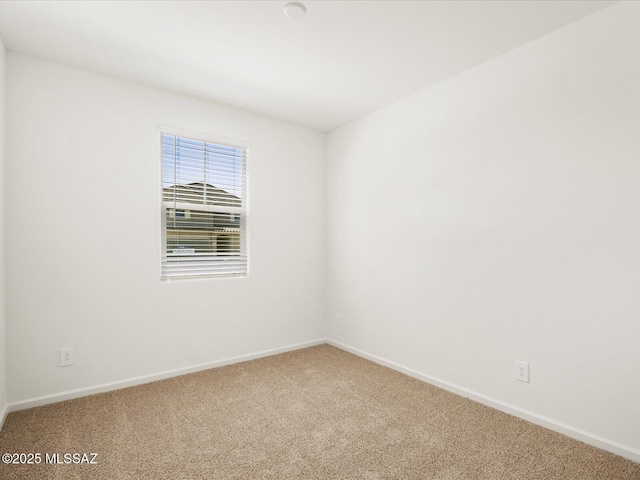 carpeted spare room with baseboards