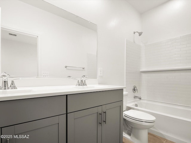 full bathroom featuring toilet, bathing tub / shower combination, double vanity, and tile patterned flooring