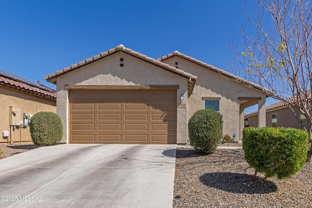 view of front of home with driveway, a tiled roof, an attached garage, and stucco siding