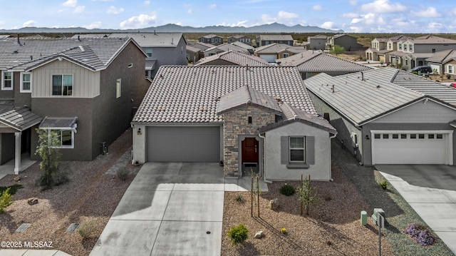 view of front of property with a residential view, driveway, a tiled roof, and a mountain view