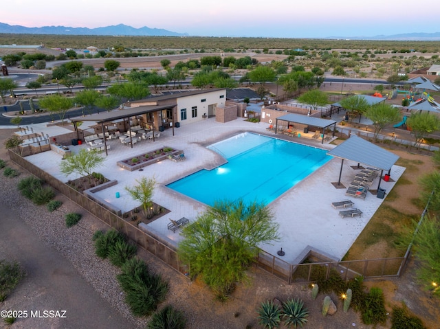 community pool with fence, a mountain view, a pergola, and a patio