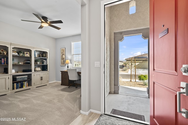 entryway with light wood-type flooring, ceiling fan, and baseboards