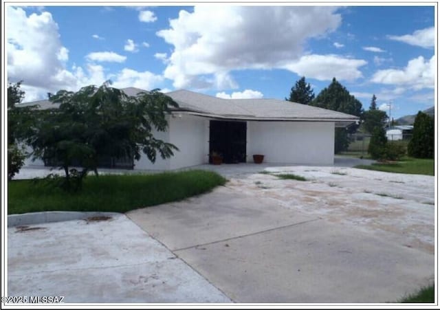 view of front of house with stucco siding and concrete driveway