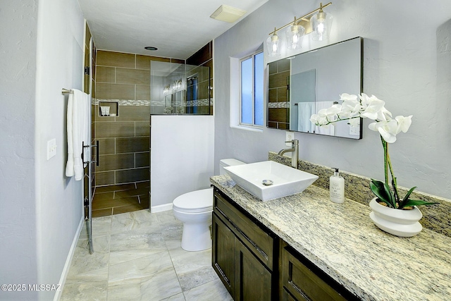 bathroom featuring marble finish floor, visible vents, toilet, a stall shower, and baseboards