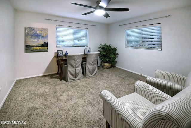 carpeted office space with ceiling fan and baseboards