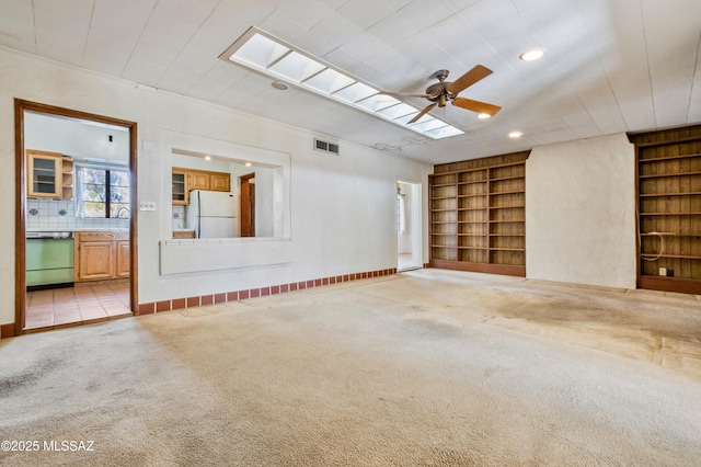 unfurnished room featuring built in shelves, carpet flooring, and visible vents