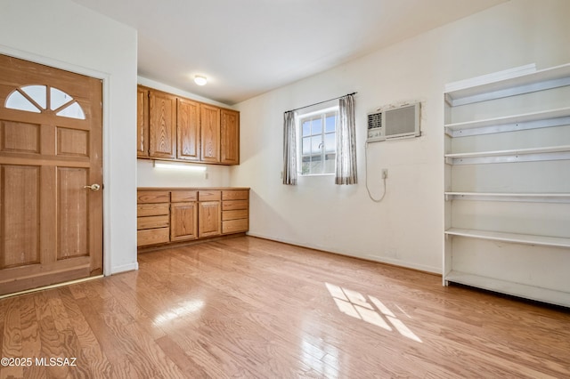 interior space featuring an AC wall unit and light wood-style flooring