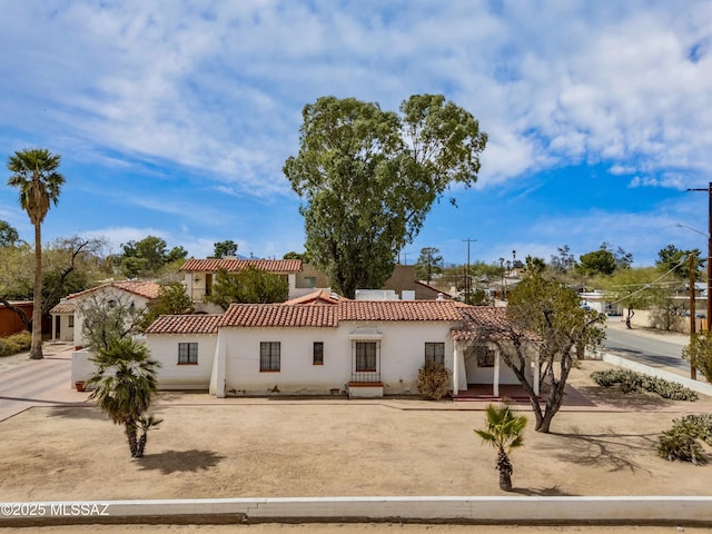 mediterranean / spanish-style home with a tile roof and stucco siding