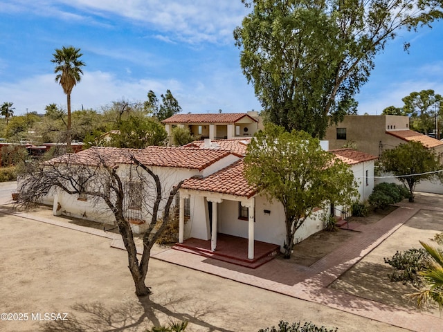 mediterranean / spanish house with a tile roof and stucco siding