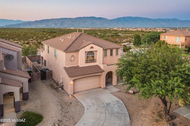 mediterranean / spanish home with concrete driveway, a tile roof, and a mountain view