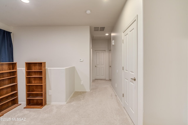 hallway with carpet floors, recessed lighting, visible vents, and an upstairs landing